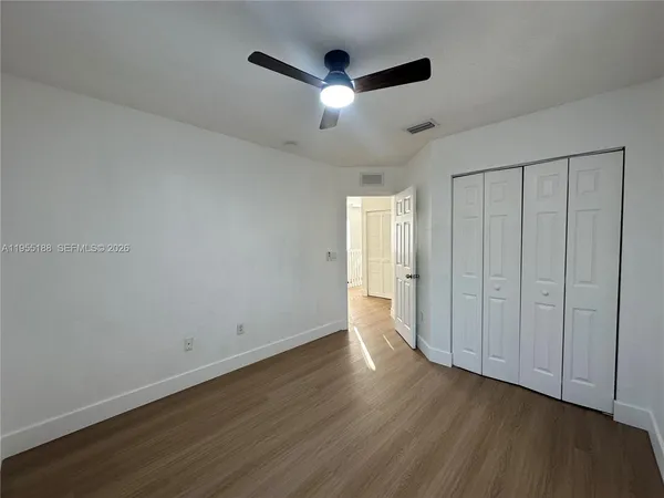 a view of an empty room with wooden floor