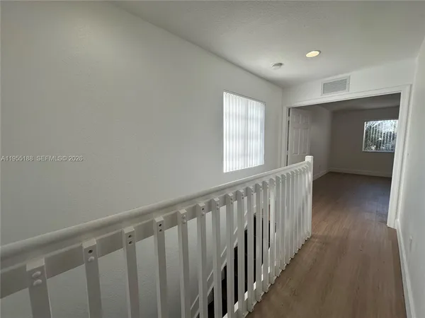 a view of hallway with wooden floor