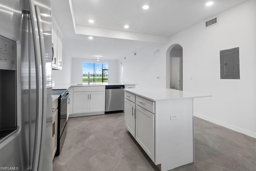 5651 Double Eagle Circle, Unit 4314 Immokalee, FL 34142 - Photo 1 of 41 Kitchen featuring appliances with stainless steel finishes, white cabinets, electric panel, recessed lighting, and a kitchen island