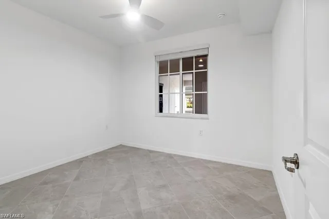 a living room with furniture flowers and wooden floor