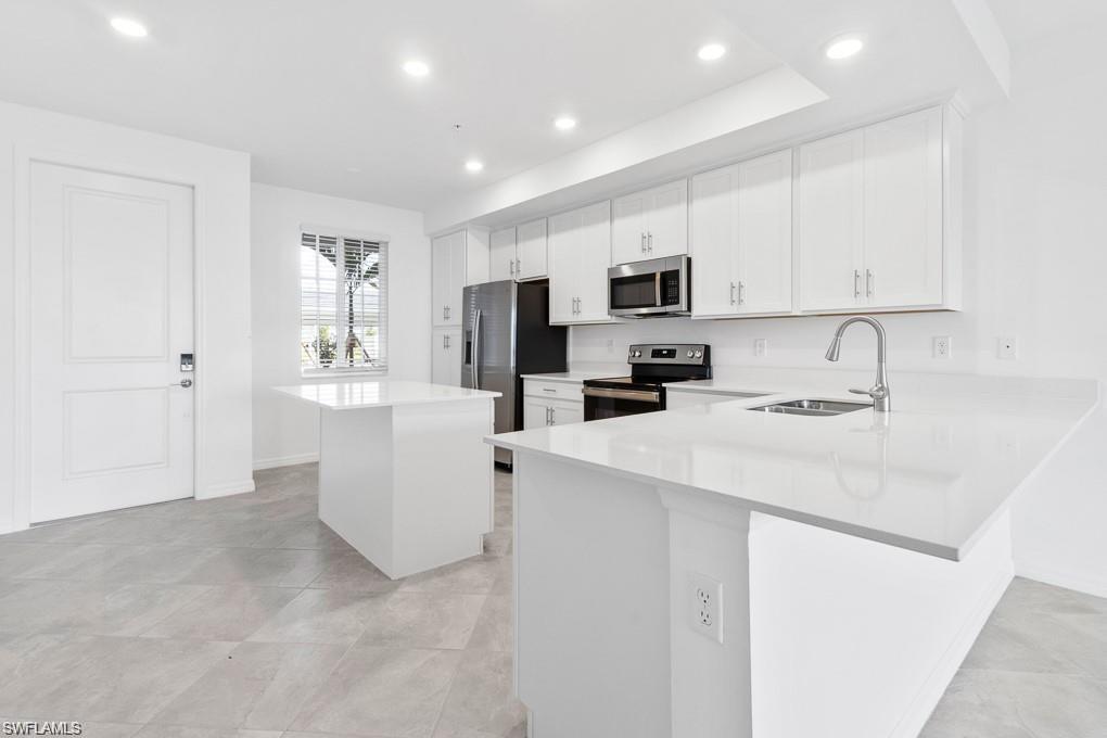 5651 Double Eagle Circle, Unit 4314 Immokalee, FL 34142 - Photo 2 of 41 Kitchen with a center island, white cabinetry, stainless steel appliances, a peninsula, and recessed lighting