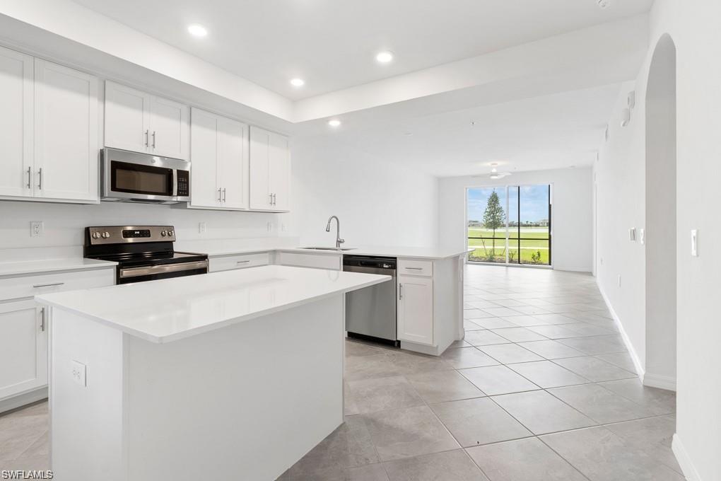 5651 Double Eagle Circle, Unit 4314 Immokalee, FL 34142 - Photo 3 of 41 Kitchen featuring appliances with stainless steel finishes, white cabinets, recessed lighting, a center island, and light tile patterned floors