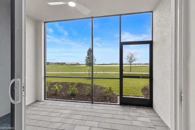 a living room with patio furniture and a floor to ceiling window