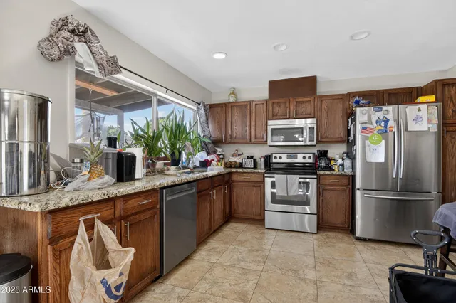 a kitchen with stainless steel appliances granite countertop a refrigerator sink and stove
