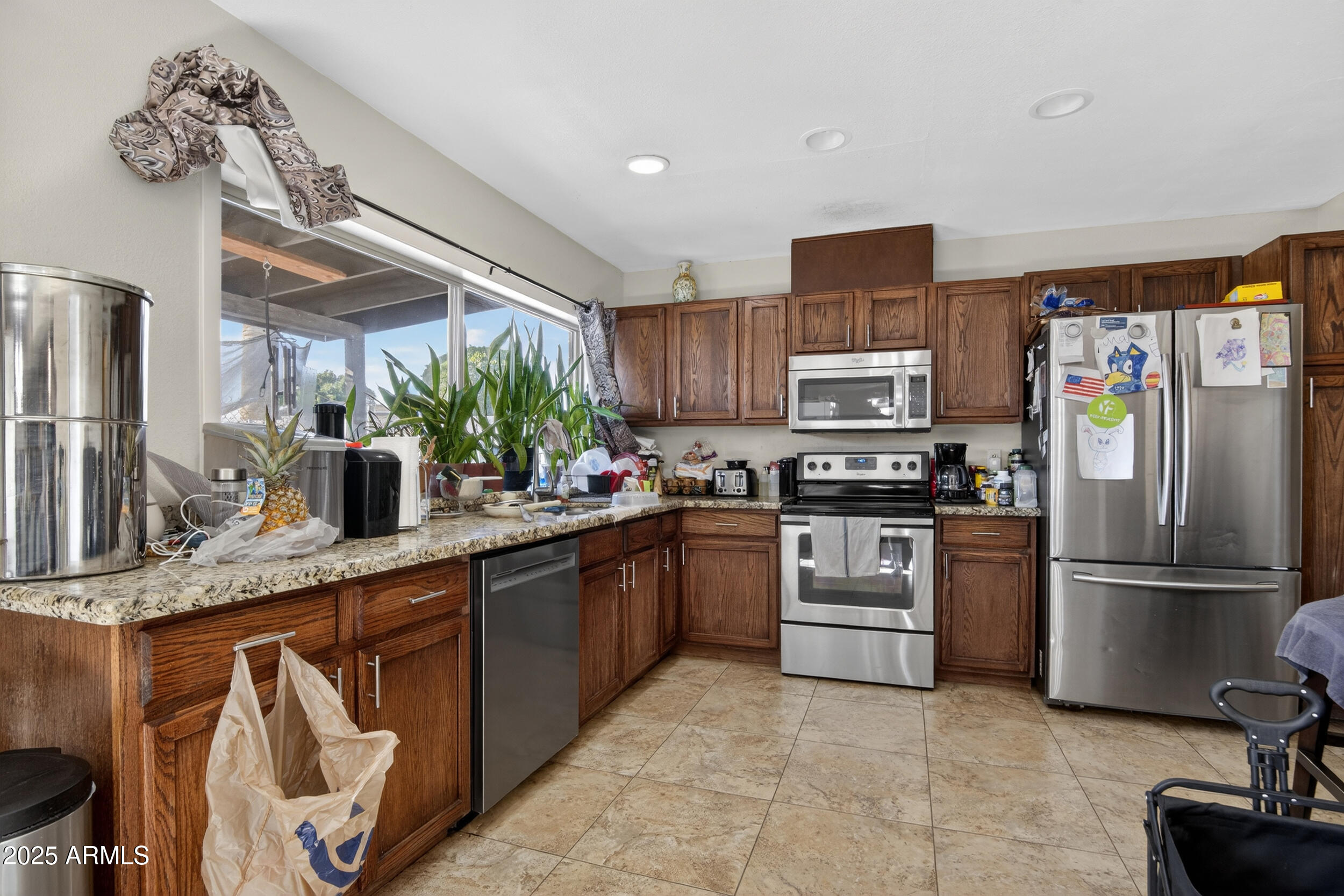3939 West Cholla Street Phoenix, AZ 85029 - Photo 3 of 11 a kitchen with stainless steel appliances granite countertop a refrigerator sink and stove
