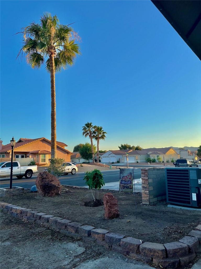 1395 Lause Road Bullhead City, AZ 86442 - Photo 34 of 34 Landscaped front yard featuring a low retaining wall, decorative boulders, and a young tree planting