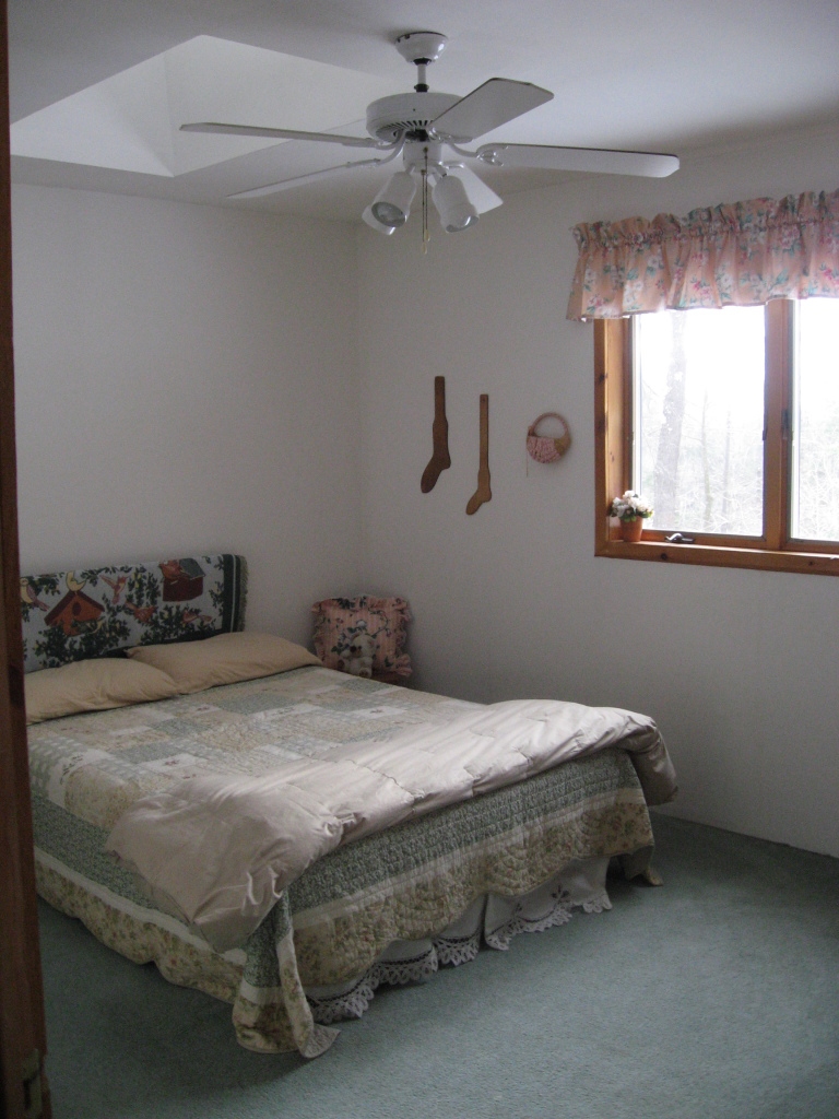 143-151 Rainbow Road Otis, MA 01029 - Photo 14 of 18 a bed sitting in a bedroom next to a window