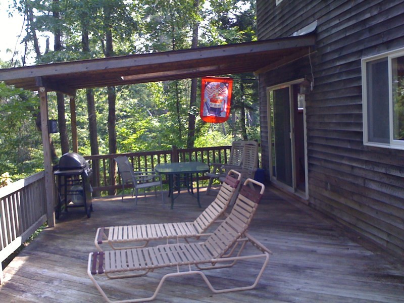 143-151 Rainbow Road Otis, MA 01029 - Photo 8 of 18 a view of a patio with a table chairs and a floor to ceiling window
