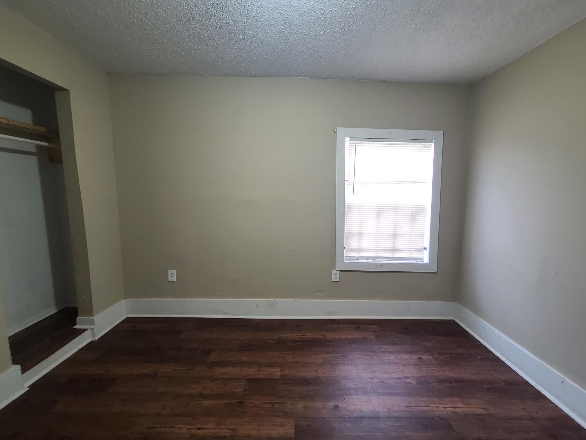 731 Flynn Road Memphis, TN 38109 - Photo 12 of 15 Wood-finish flooring with white trim, a single window with blinds, and an open closet space