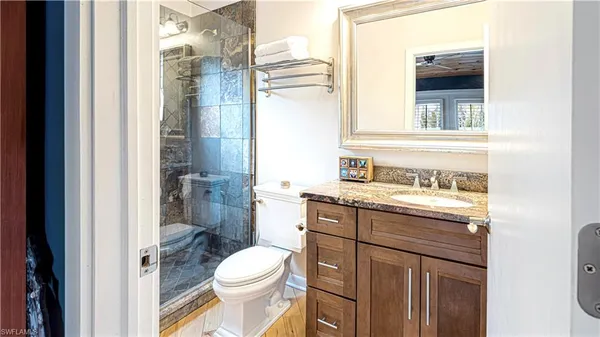 a bathroom with a granite countertop toilet sink and a shower
