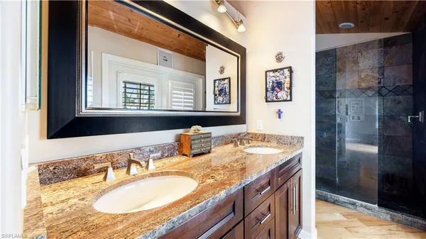 a bathroom with a granite countertop sink and a mirror