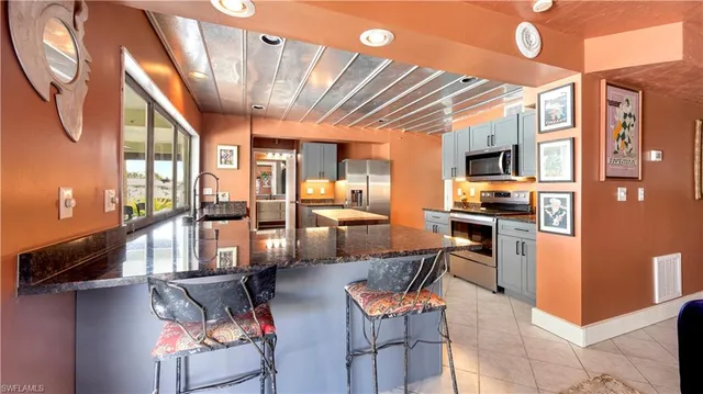 a living room with stainless steel appliances kitchen island granite countertop furniture and a kitchen view