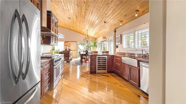 a kitchen with stainless steel appliances kitchen island granite countertop a refrigerator and a stove