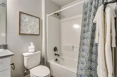 a bathroom with a toilet and a shower curtain