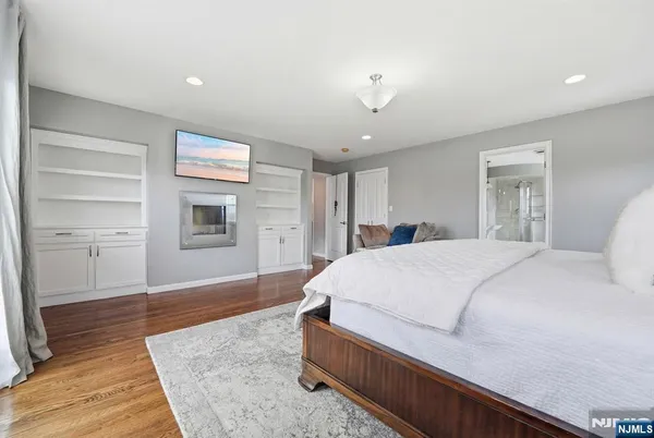 a spacious bedroom with a bed and a dresser