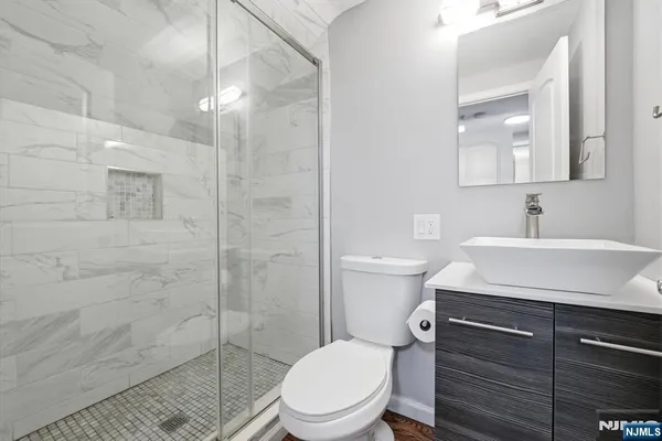 a bathroom with a sink a toilet and shower