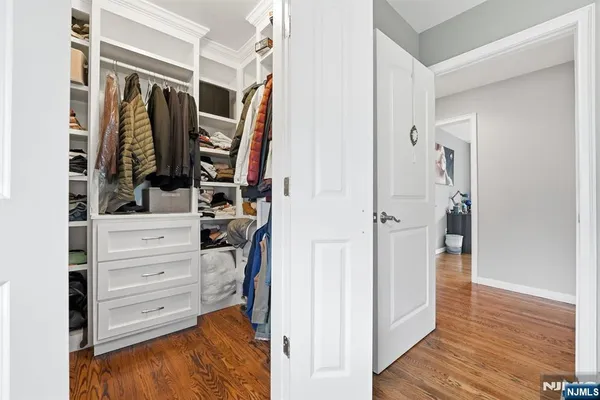 a view of walk in closet with clothes and shoes