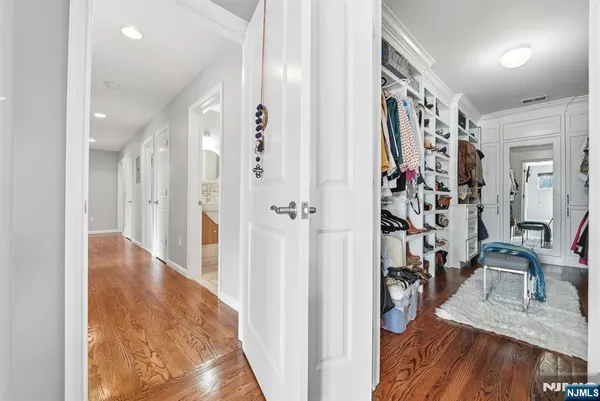 a view of a hallway with wooden floor and living room