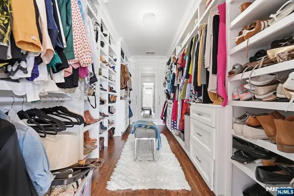 a view of walk in closet with clothes and shoes