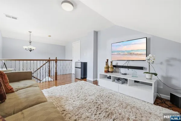 a living room with furniture a flat screen tv and white walls
