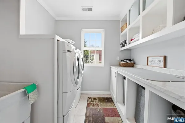 a utility room with cabinets washer and dryer