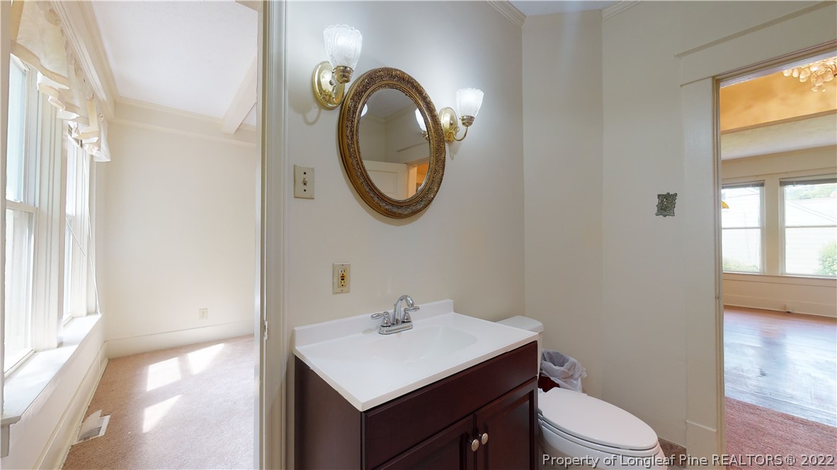 1913 Morganton Road Fayetteville, NC 28305 - Photo 33 of 45 a bathroom with a toilet a sink and a mirror