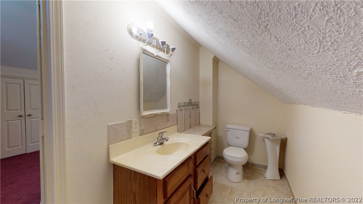 1913 Morganton Road Fayetteville, NC 28305 - Photo 45 of 45 a bathroom with a toilet a sink and mirror