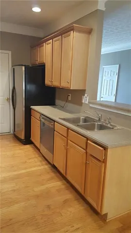 a kitchen with stainless steel appliances granite countertop a refrigerator and a sink