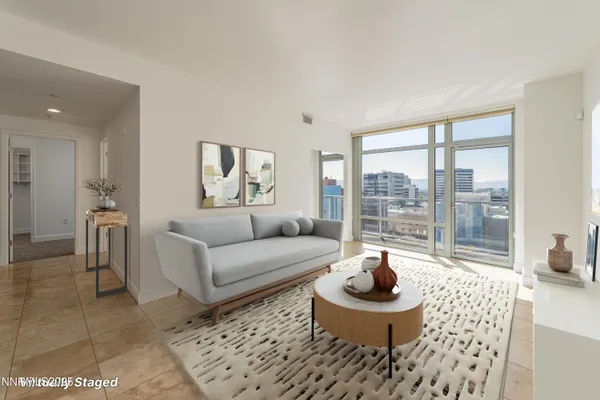 a living room with furniture and a floor to ceiling window