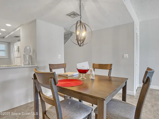 a view of a dining room with furniture a chandelier and wooden floor
