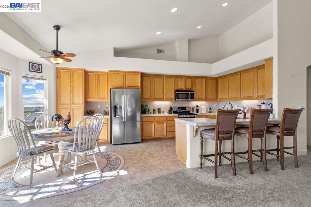 1105 Paradise Peak Road Valley Springs, CA 95252 - Photo 16 of 52 a kitchen with stainless steel appliances granite countertop a stove top oven a refrigerator a sink dishwasher a dining table and chairs with wooden floor