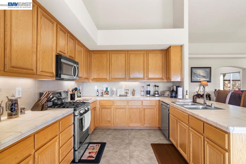 1105 Paradise Peak Road Valley Springs, CA 95252 - Photo 18 of 52 a kitchen with stainless steel appliances granite countertop white cabinets sink stove and microwave