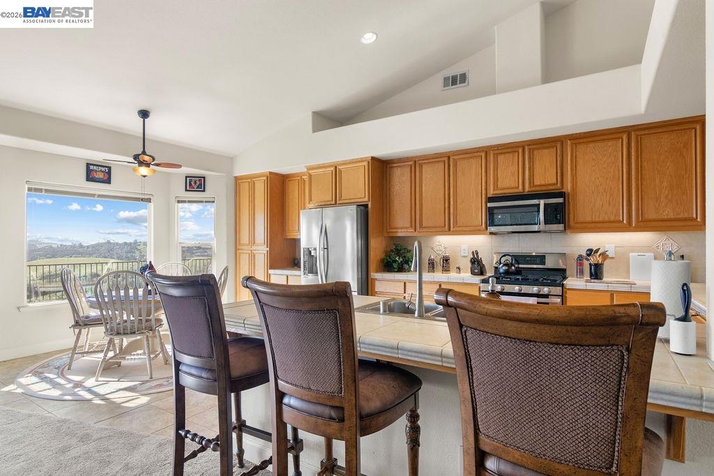1105 Paradise Peak Road Valley Springs, CA 95252 - Photo 20 of 52 a kitchen with stainless steel appliances granite countertop a sink a stove a refrigerator cabinets dining table and chairs