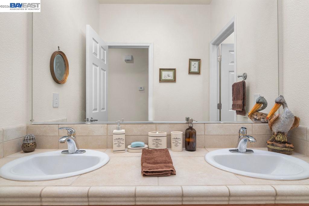 1105 Paradise Peak Road Valley Springs, CA 95252 - Photo 24 of 52 a bathroom with double vanity sinks and a mirror