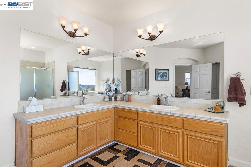 1105 Paradise Peak Road Valley Springs, CA 95252 - Photo 36 of 52 a bathroom with a double vanity sink and a mirror
