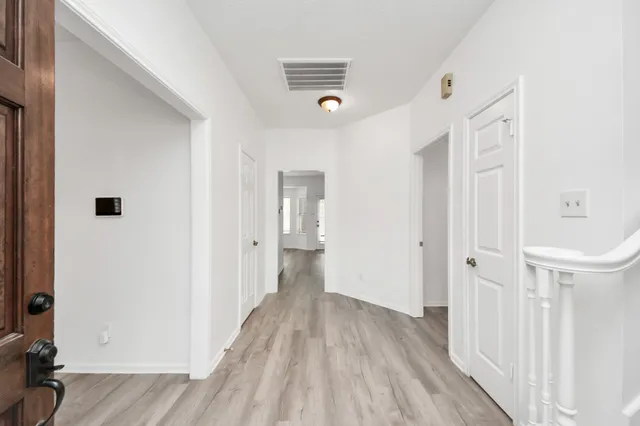 a view of a hallway with wooden floor and closet area