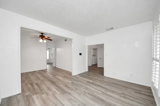 a view of a livingroom with wooden floor and a ceiling fan