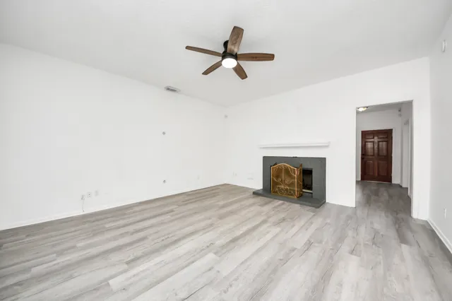 a view of empty room with wooden floor and fireplace