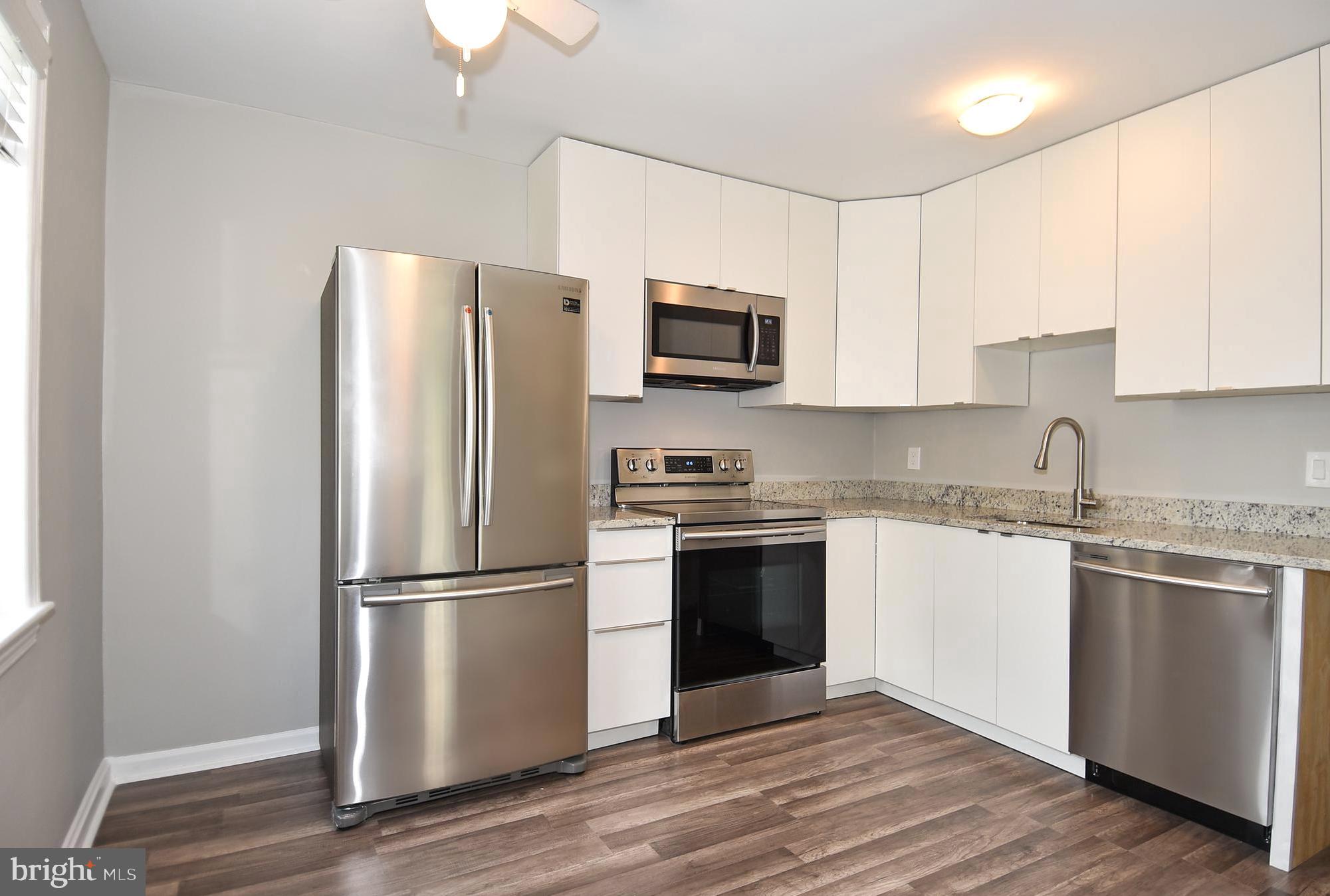 7036 Strathmore Street, Unit 311 Chevy Chase, MD 20815 - Photo 2 of 27 a kitchen with a refrigerator stove and microwave