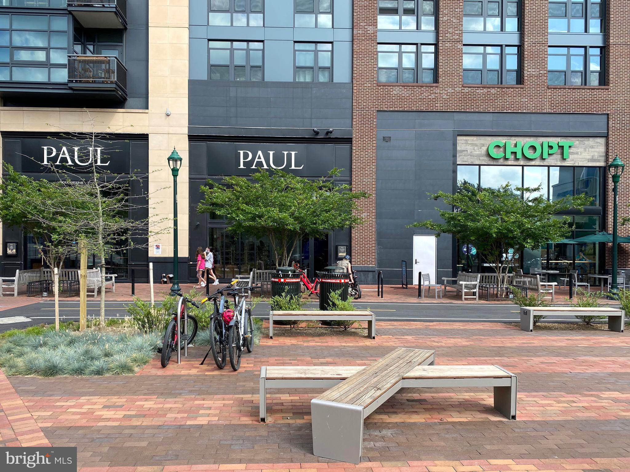 7036 Strathmore Street, Unit 311 Chevy Chase, MD 20815 - Photo 26 of 27 a view of a building with a bench in front of building