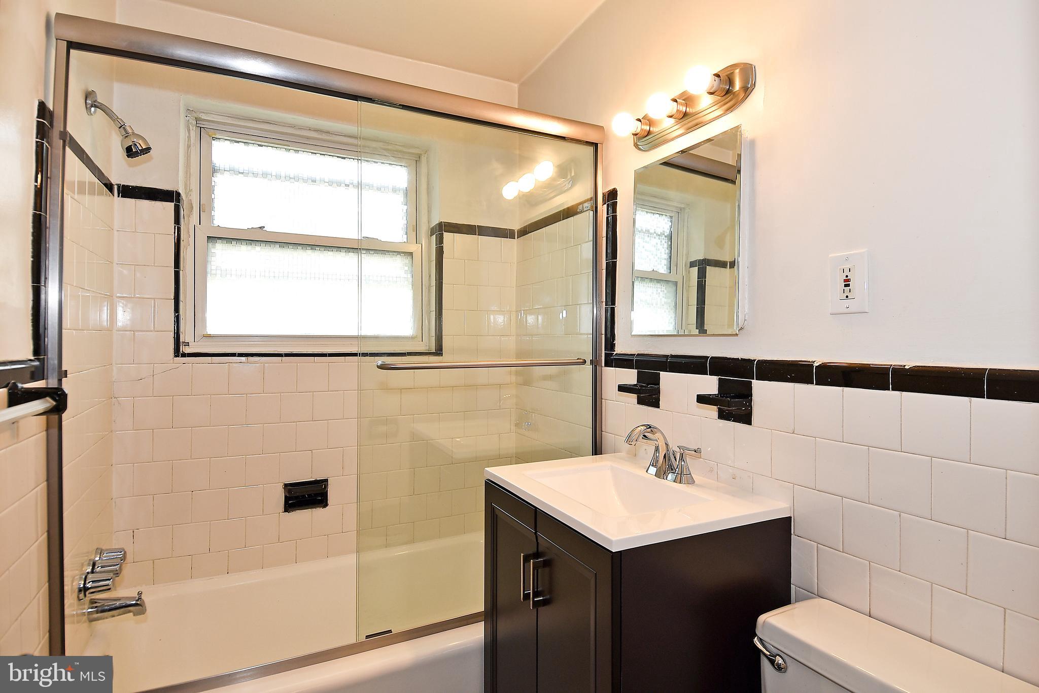 7036 Strathmore Street, Unit 311 Chevy Chase, MD 20815 - Photo 6 of 27 a bathroom with a sink toilet a mirror and shower