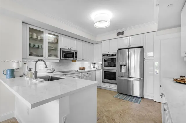 a kitchen with refrigerator a microwave a stove and white cabinets