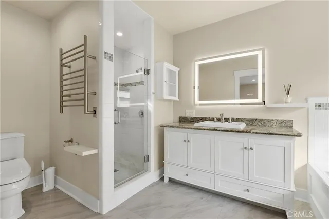 a bathroom with a granite countertop sink toilet and shower