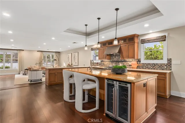 a kitchen with kitchen island granite countertop a stove and a wooden floor
