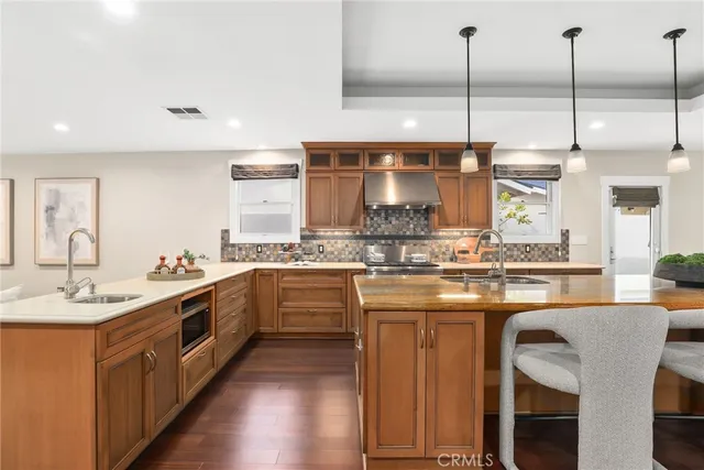a kitchen with stainless steel appliances granite countertop a sink a stove and a wooden floors