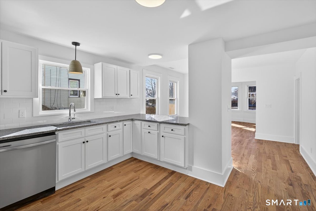 62 General Street Stratford, CT 06615 - Photo 3 of 40 a large kitchen with a wooden floor and white stainless steel appliances