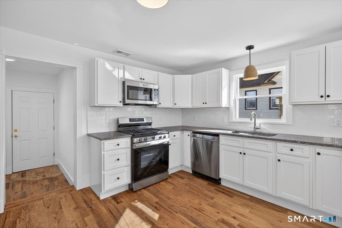 62 General Street Stratford, CT 06615 - Photo 5 of 40 a kitchen with stainless steel appliances granite countertop a sink a stove a microwave and cabinets