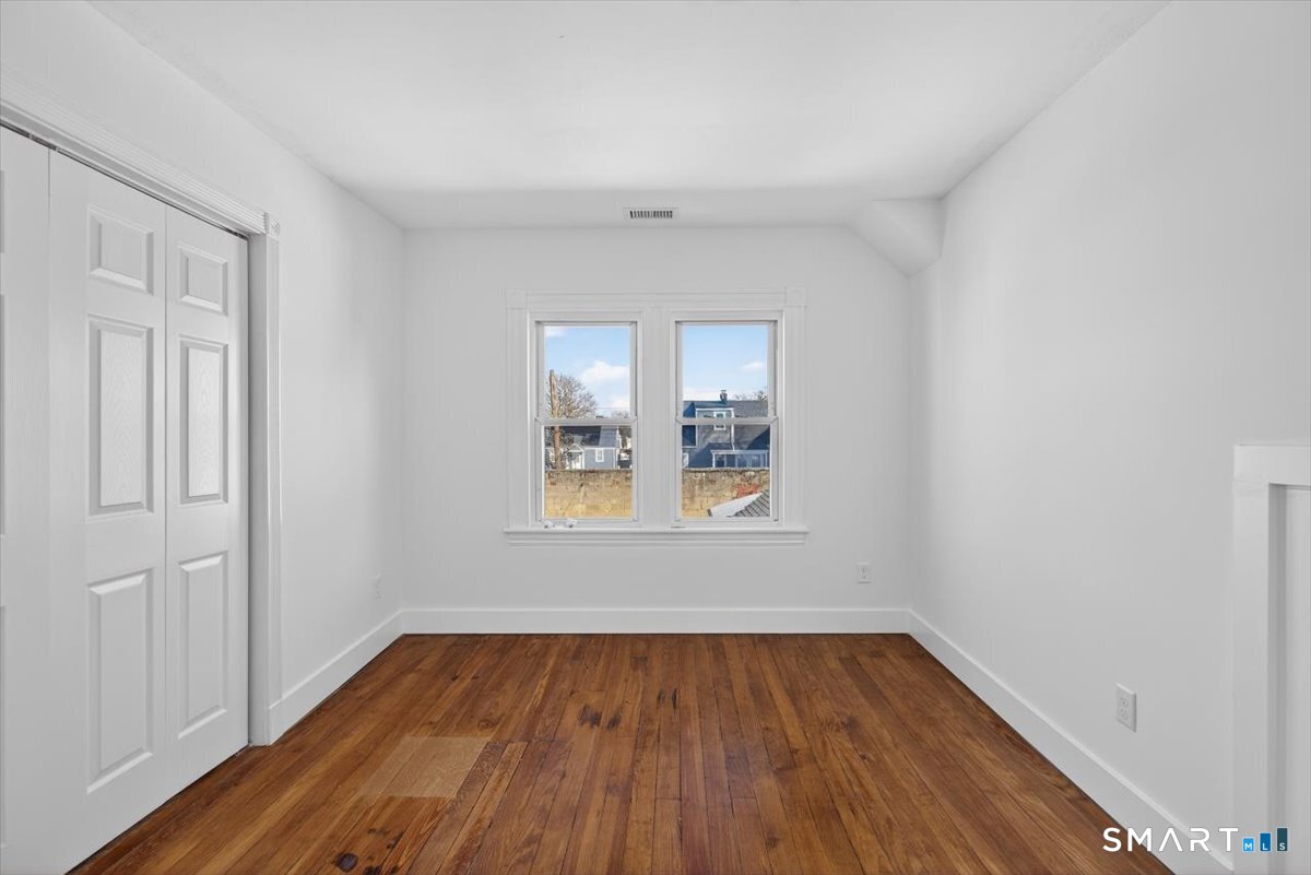 62 General Street Stratford, CT 06615 - Photo 9 of 40 an empty room with wooden floor and windows