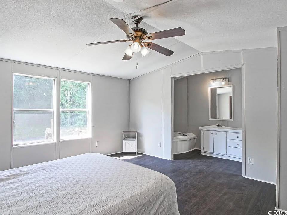 Bedroom featuring a textured ceiling, lofted ceiling, ceiling fan, and dark wood finished floors
