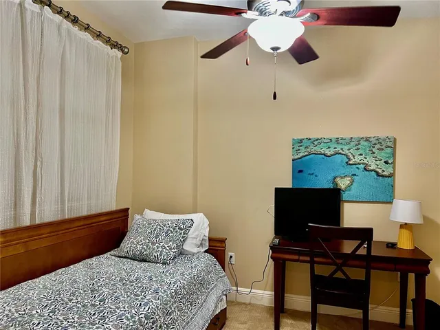 a bedroom with a bed and a large window with the outer view